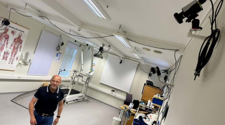 En person som står i et rom med en projektor og en projektor