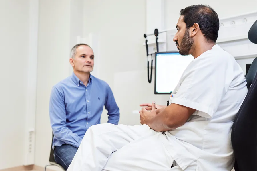 En lege som snakker med en pasient