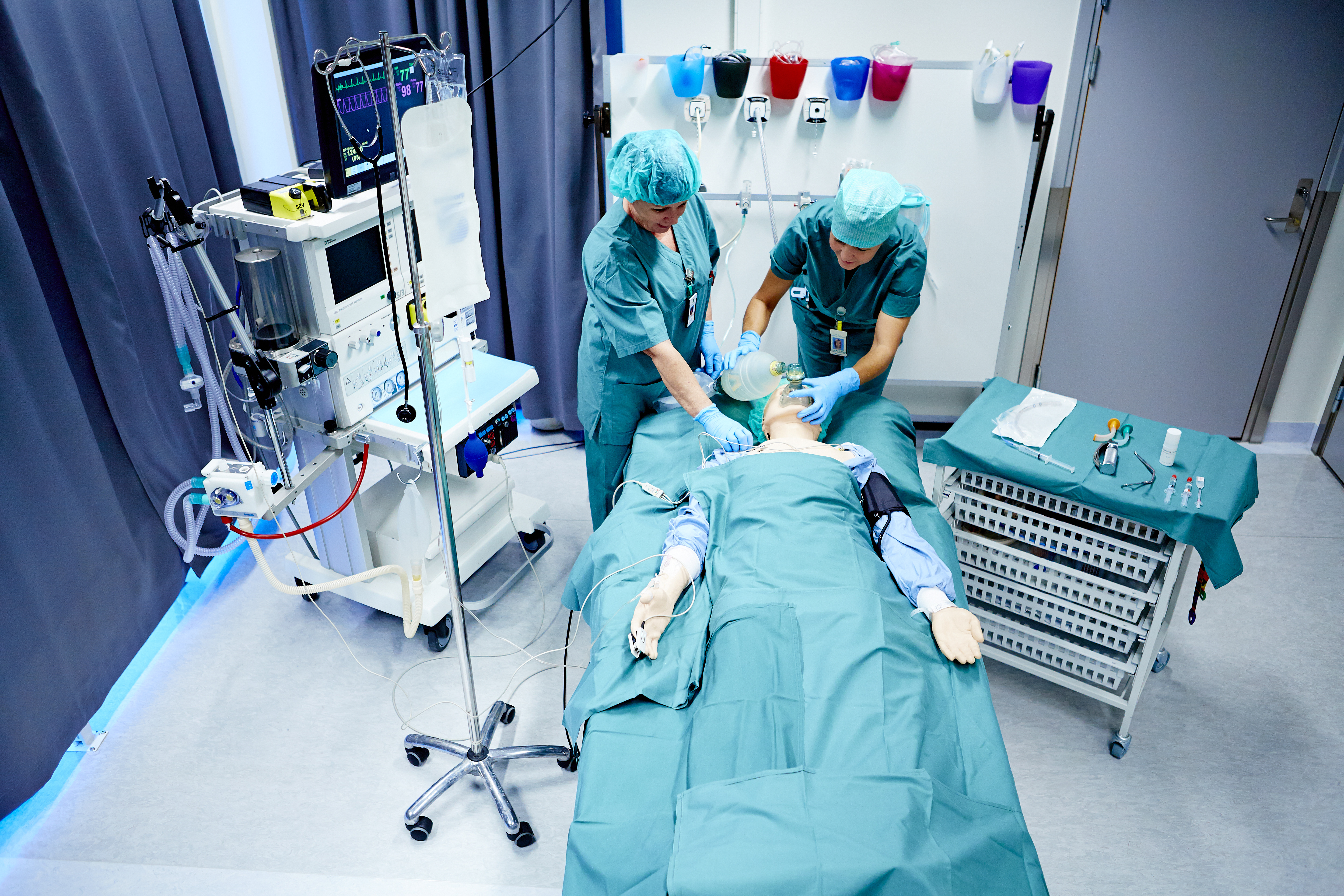 To ansatte som behandler simuleringsdukke i simuleringssenteret