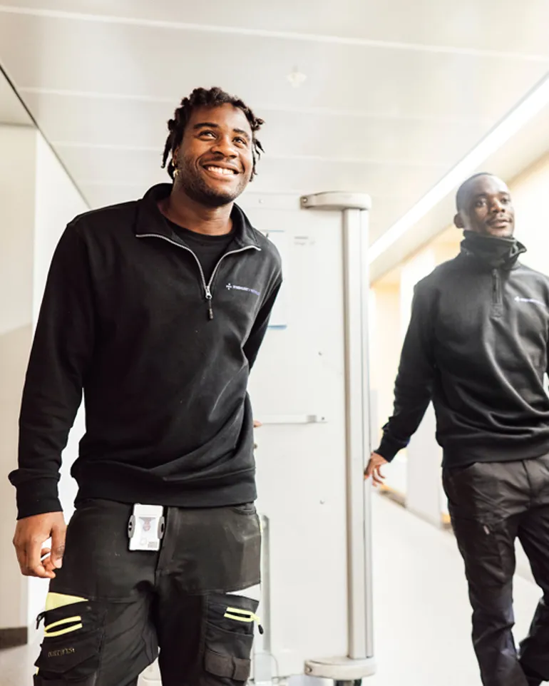 Et par menn som går i gangen