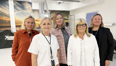 Fem kvinner står samlet_