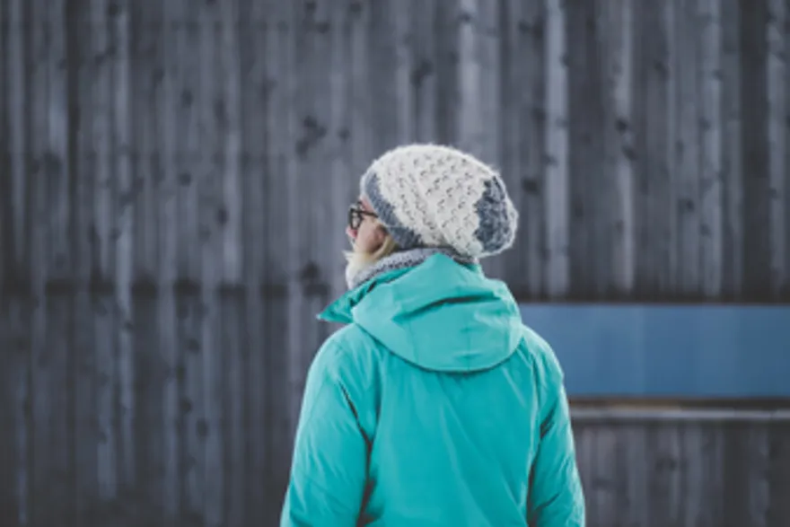 Kvinne med lue og jakke sett bakfra