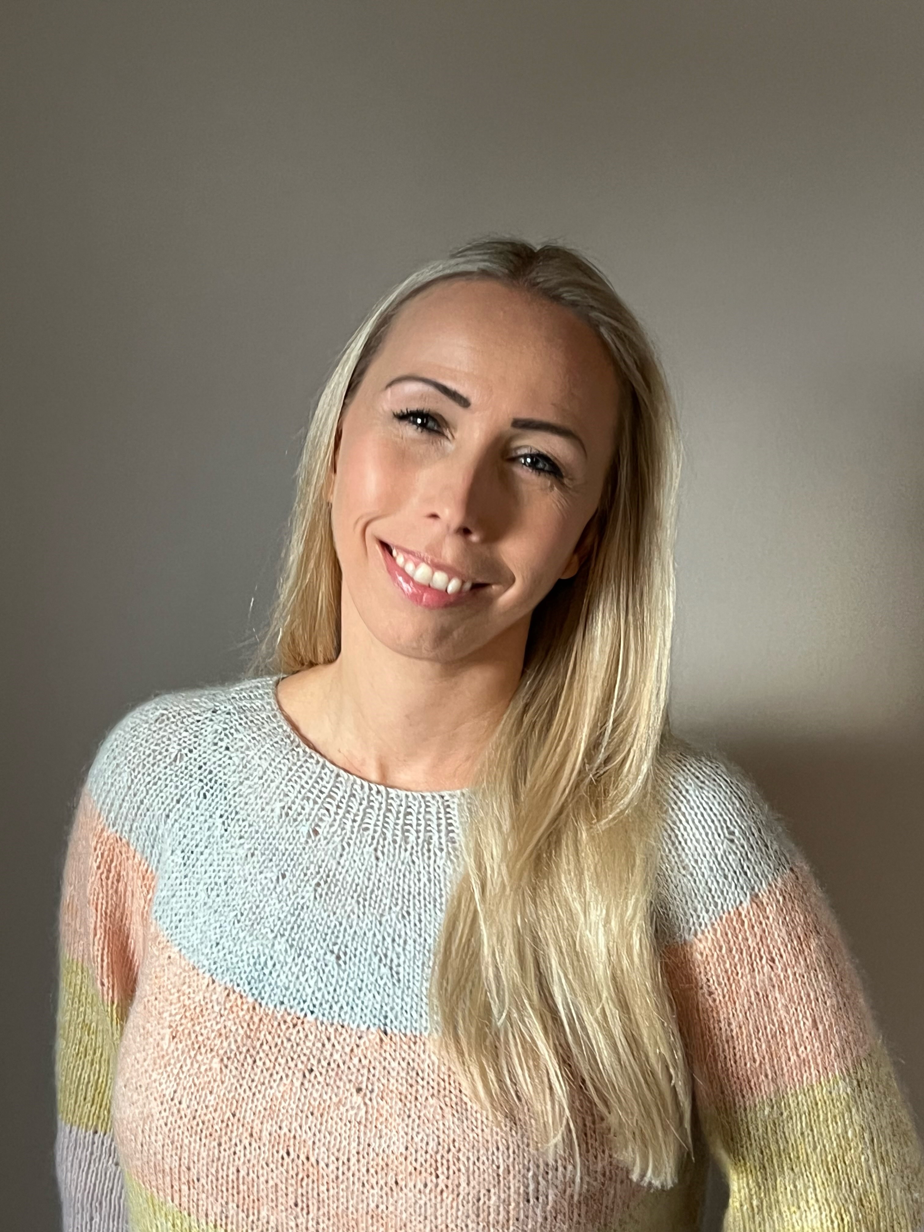 En kvinne som smiler til kameraet