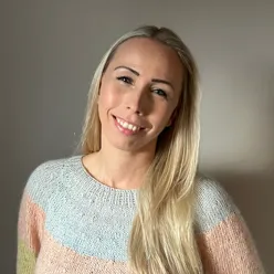 En kvinne som smiler til kameraet