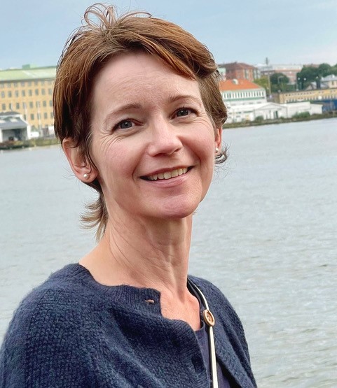 En kvinne som smiler til kameraet