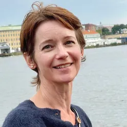 En kvinne som smiler til kameraet