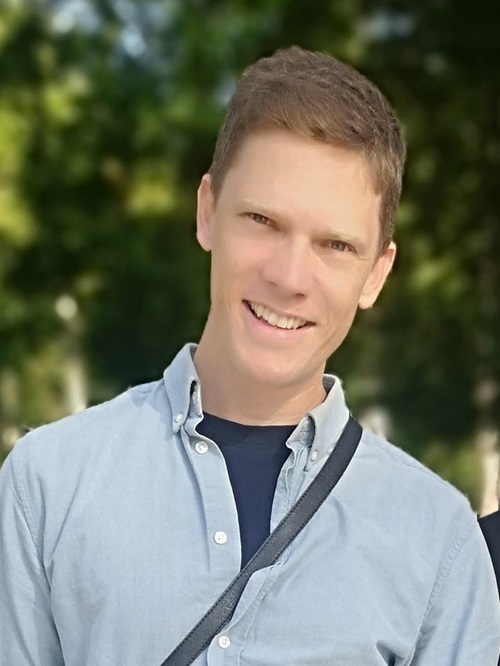 En mann som smiler til kameraet