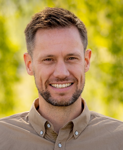 En mann som smiler til kameraet