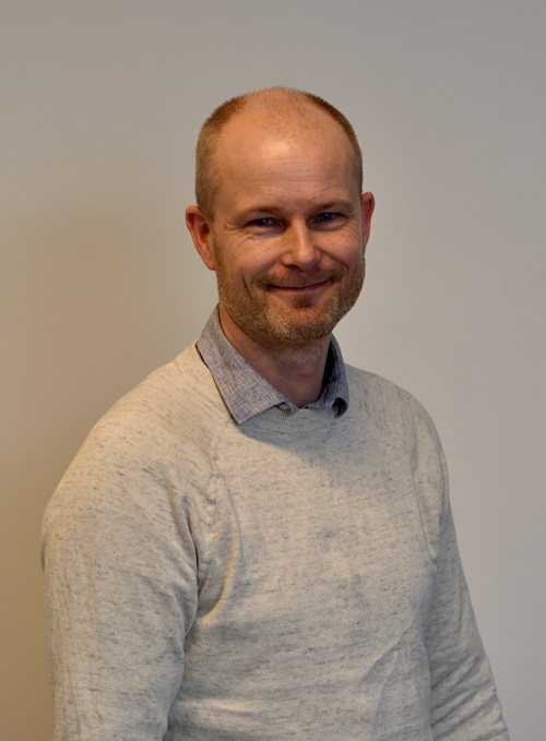 En mann som smiler til kameraet