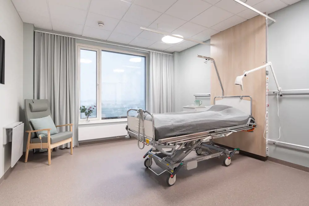 Et sykehusrom med seng og stol